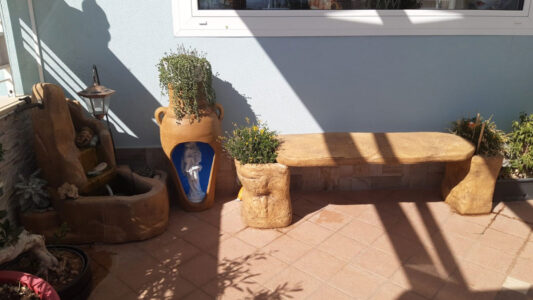 <a href="/prodotti/articoli-sacri-nicchie-madonne/madonna-con-gesu-bambino-in-marmoresina/">statua della Madonna con Gesù bambino</a> in marmoresina, <a href="/prodotti/fontane-da-giardino/fontana-piave-con-gioco-d-acqua/">fontana Piave con gioco d'acqua</a> e <a href="/prodotti/tavoli-e-panchine-per-giardino/panchina-roccia/">panchina roccia</a> col. old stone, Marina di Ragusa statua della Madonna con Gesù bambino in marmoresina, fontana Piave e Panchina roccia col. old stone, Marina di Ragusa